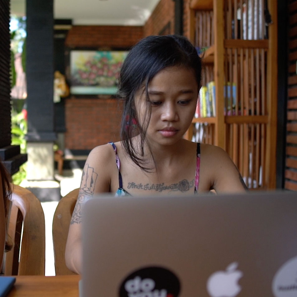 A young woman working on a laptop at a school