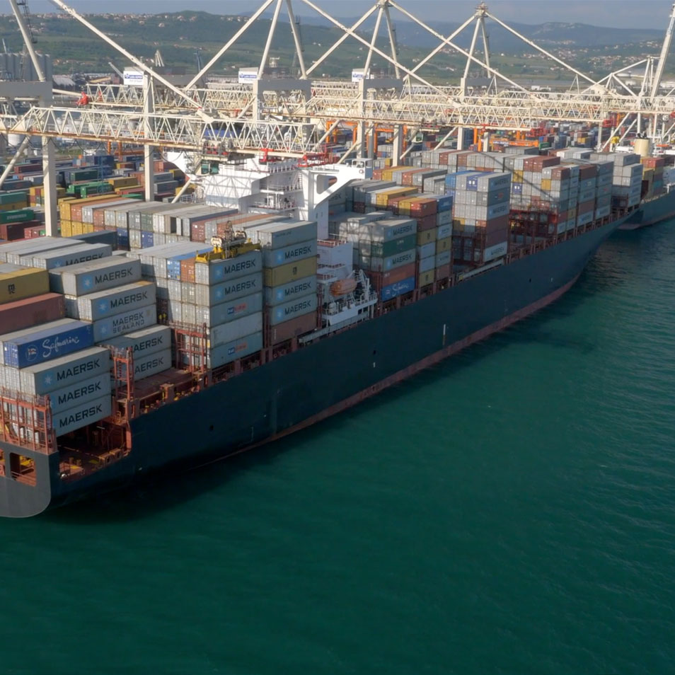 A busy urban estuary with a large freight ship approaching the harbor