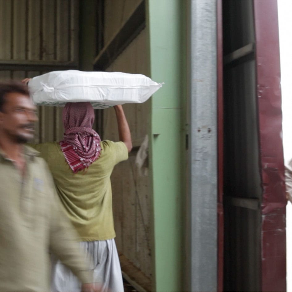 People unloading packaged goods from a truck into a warehouse